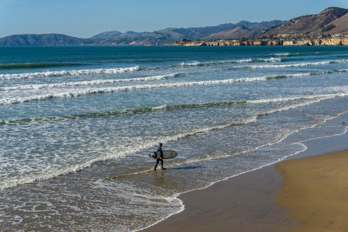 A surfer about the hit the waves in Pismo Beach